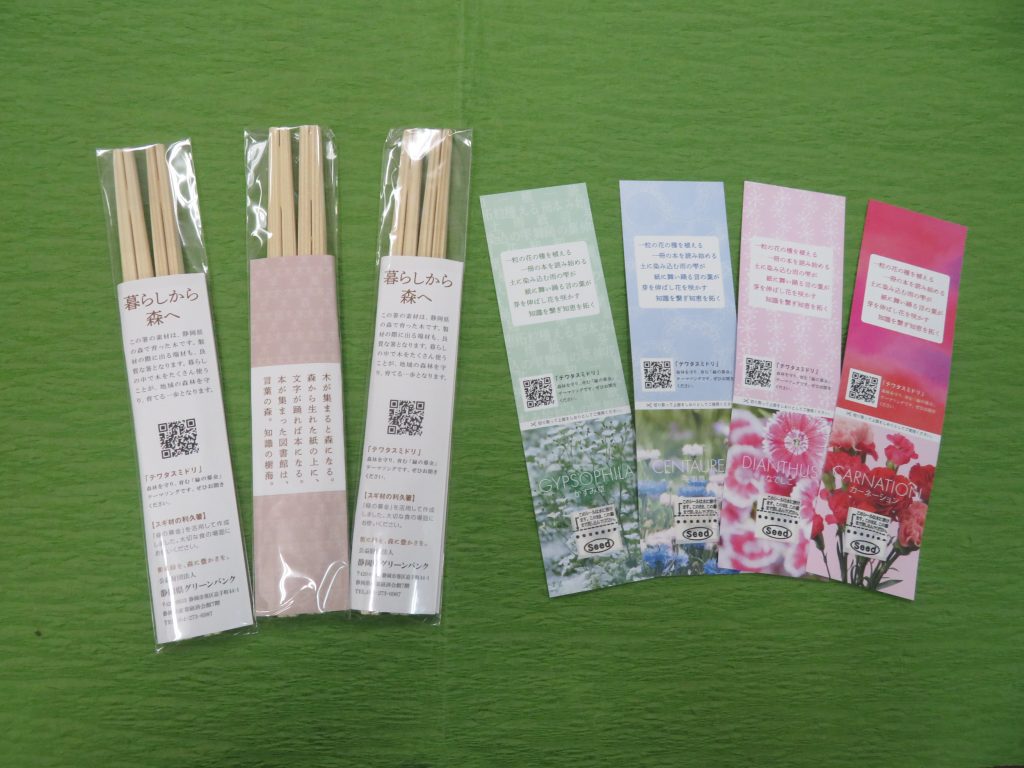 緑の背景に並べられた色とりどりの箸とそのラベルが写った画像。