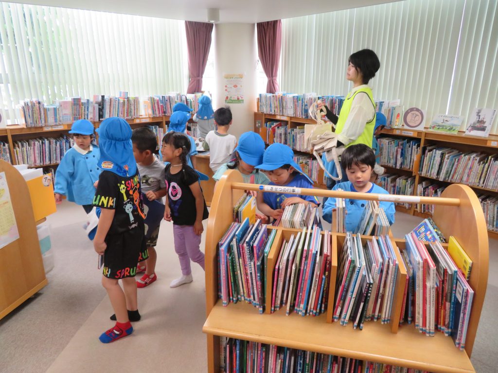 図書館で活動する子供たちが本棚の周りに集まっている様子。
