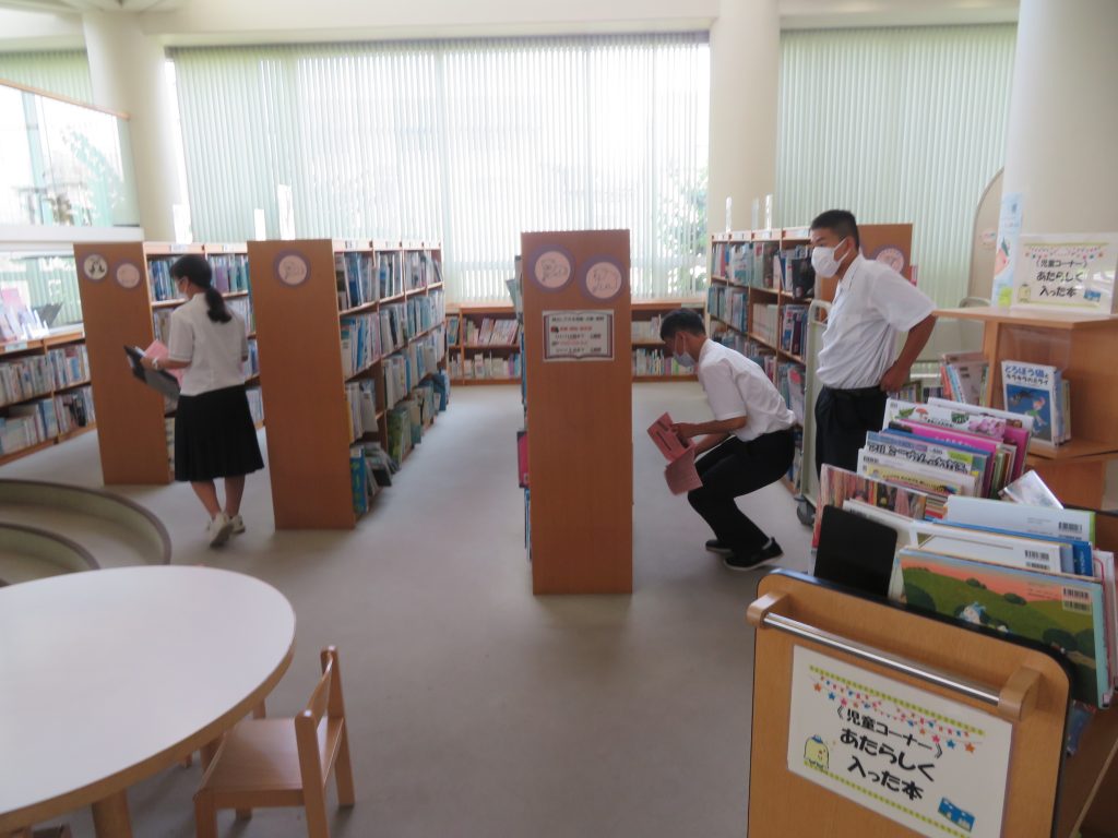 図書館内で本を探している男女の姿が写っている画像