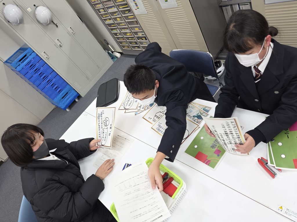 学生たちがテーブルで資料を見ながら話し合っている様子
