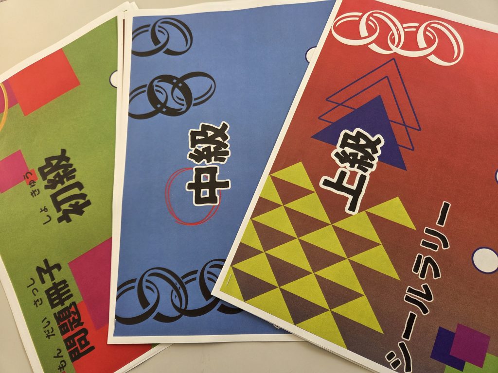 異なる色とデザインの3枚のカードが重なって置かれている画像。