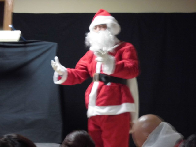 サンタクロースの衣装を着た人物が手を挙げている様子