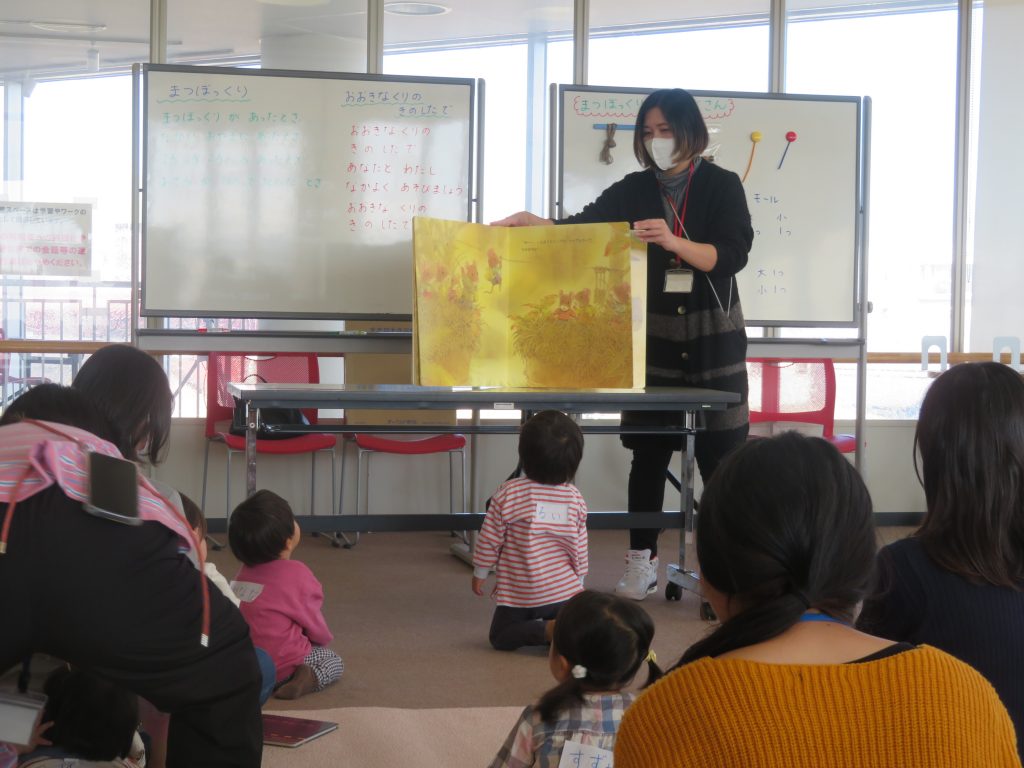 講師が子供たちに向けて大きな掲示物を見せながら説明している様子。