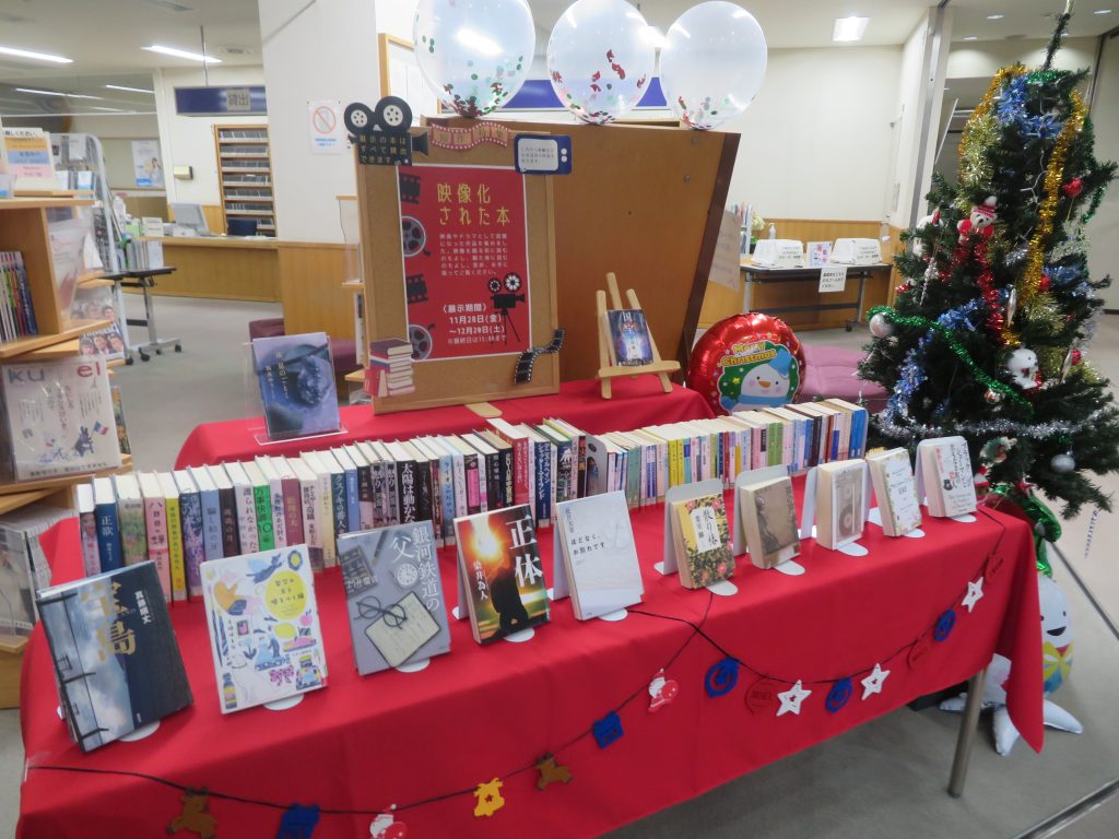 図書館の展示スペースに本や装飾が並べられたテーブルの画像。