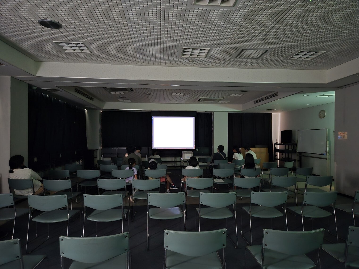 映画会会場で鑑賞する複数の人々