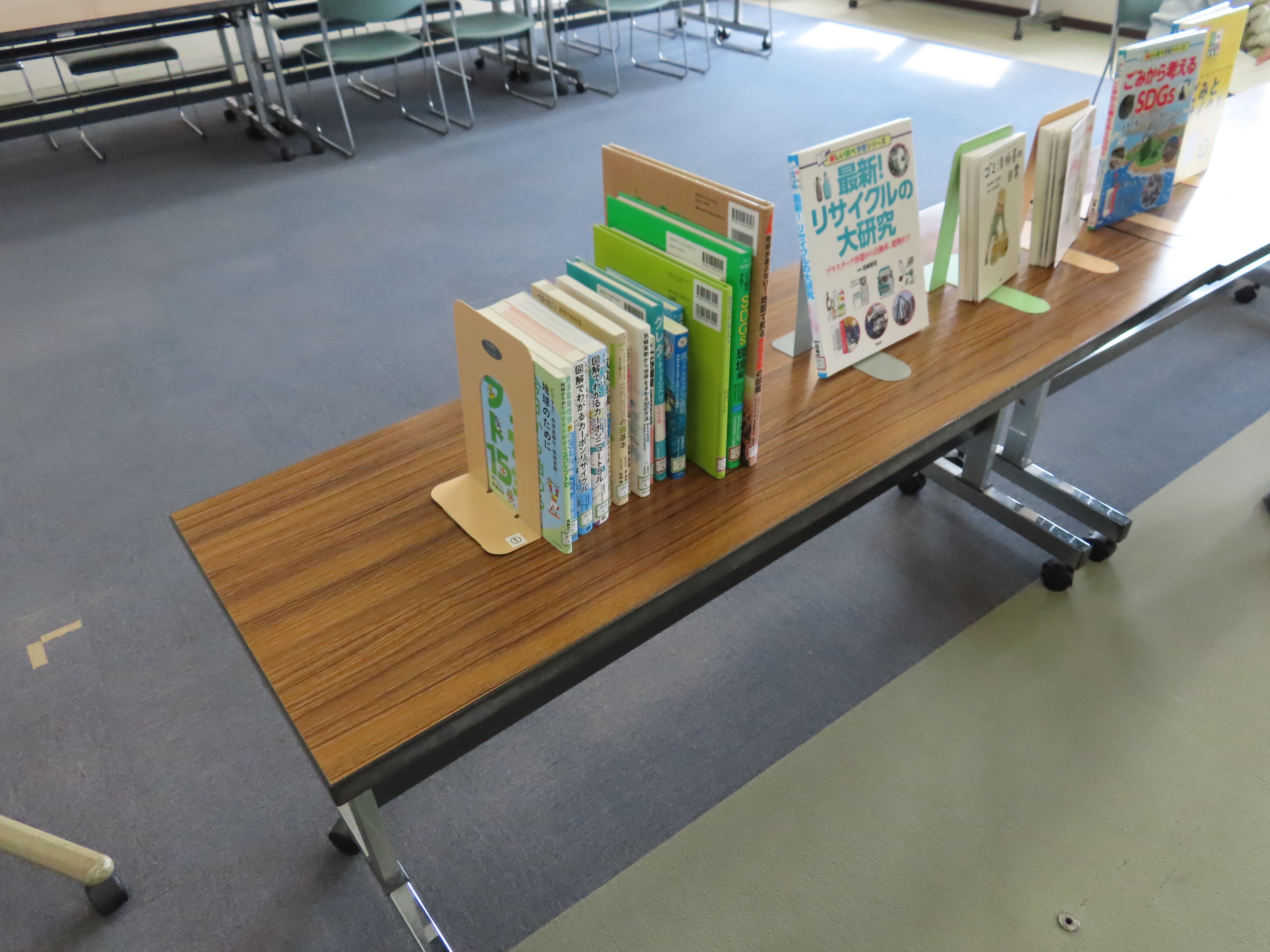 長机の上に立て札で展示された環境やリサイクルに関する本が並んでいる
