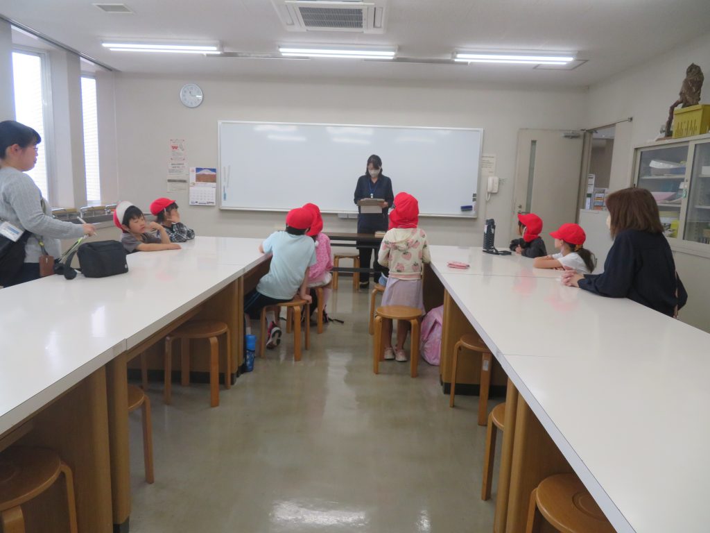 教室で講義を受ける子供たちと講師が写っている画像。