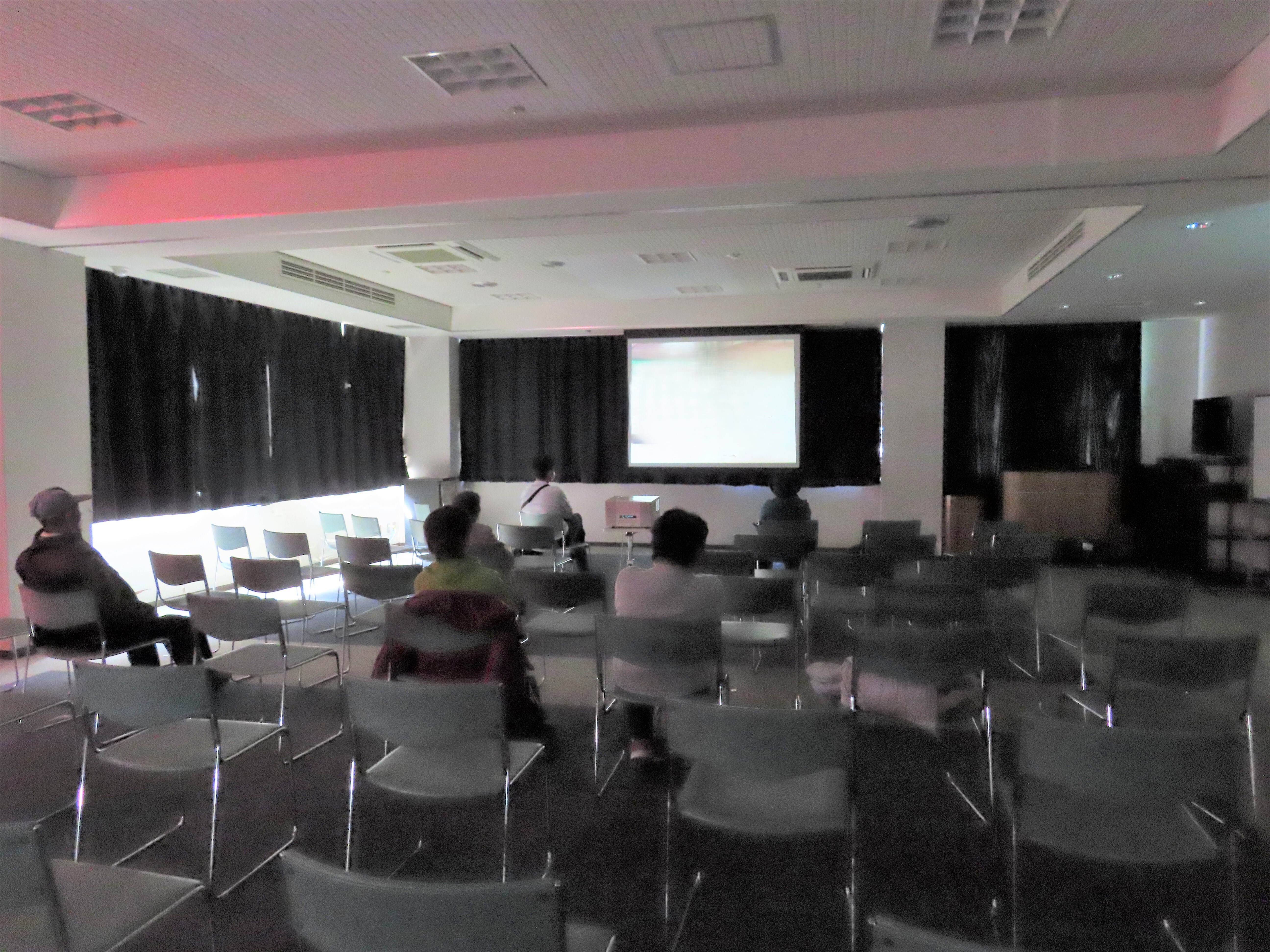 スクリーンに投影された映像を見ている観客