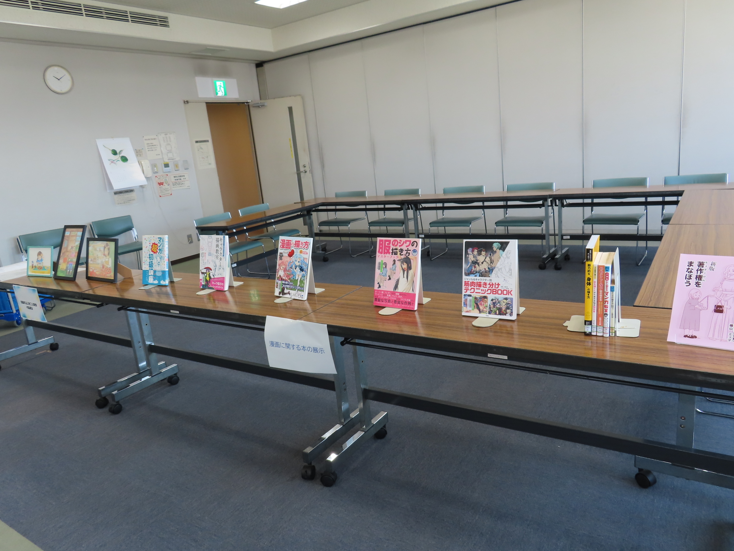 会議室の長机に本やパンフレットが立てて並べられて展示されている