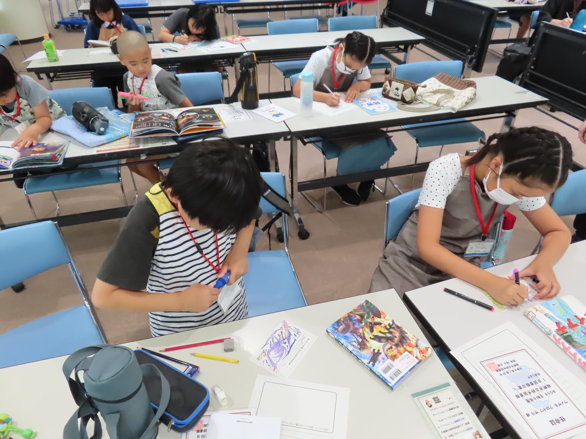 子どもたちが机に向かってポップ作りに取り組んでいる様子