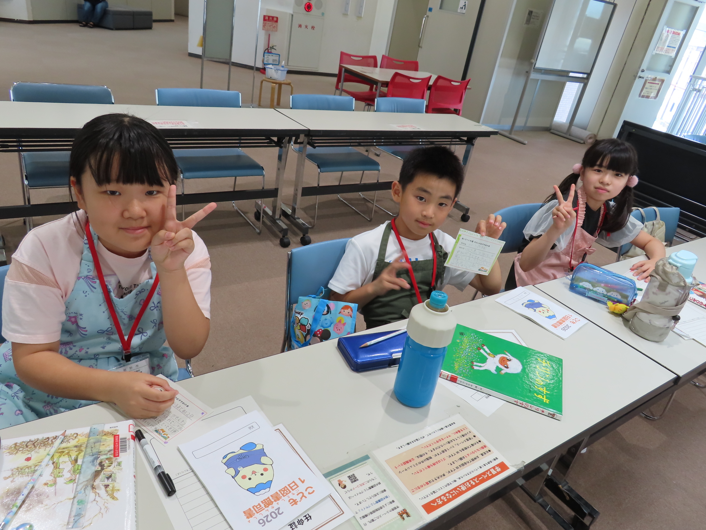 三人の子どもがカメラに向かってピースサインをしている