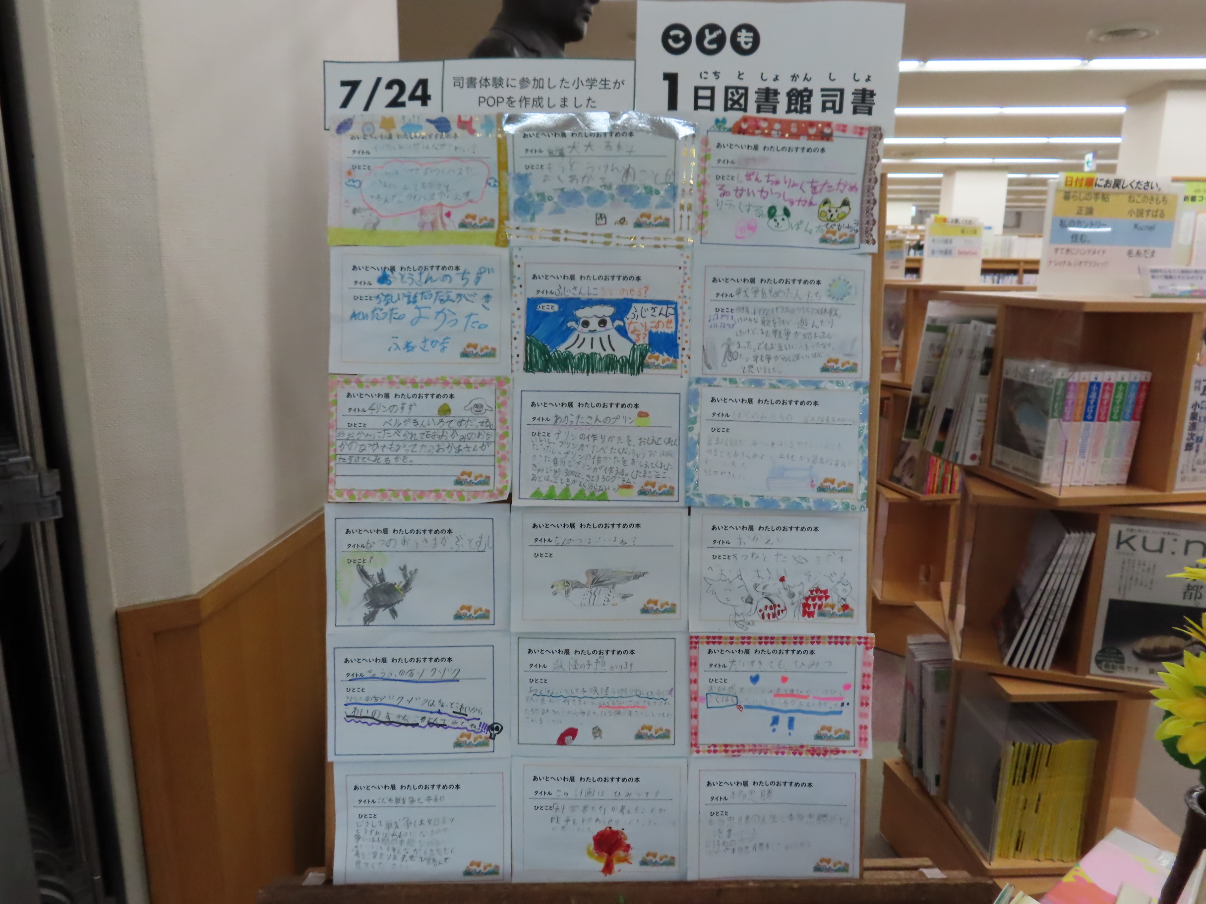 図書館の棚の前にポップの掲示板が立てられている