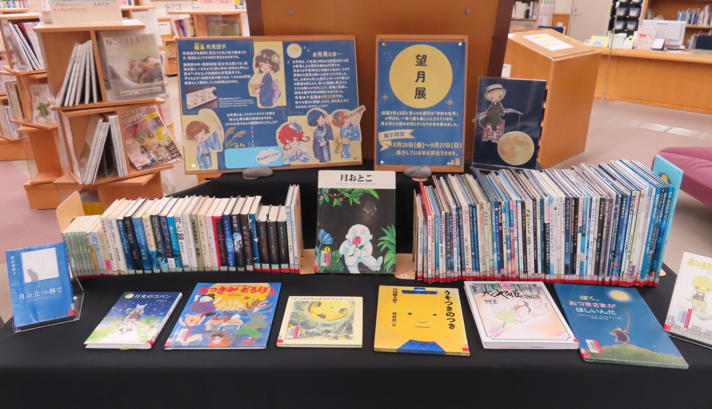 図書館のテーブルに並べられた子ども向けの絵本や児童書が見やすく展示されている様子