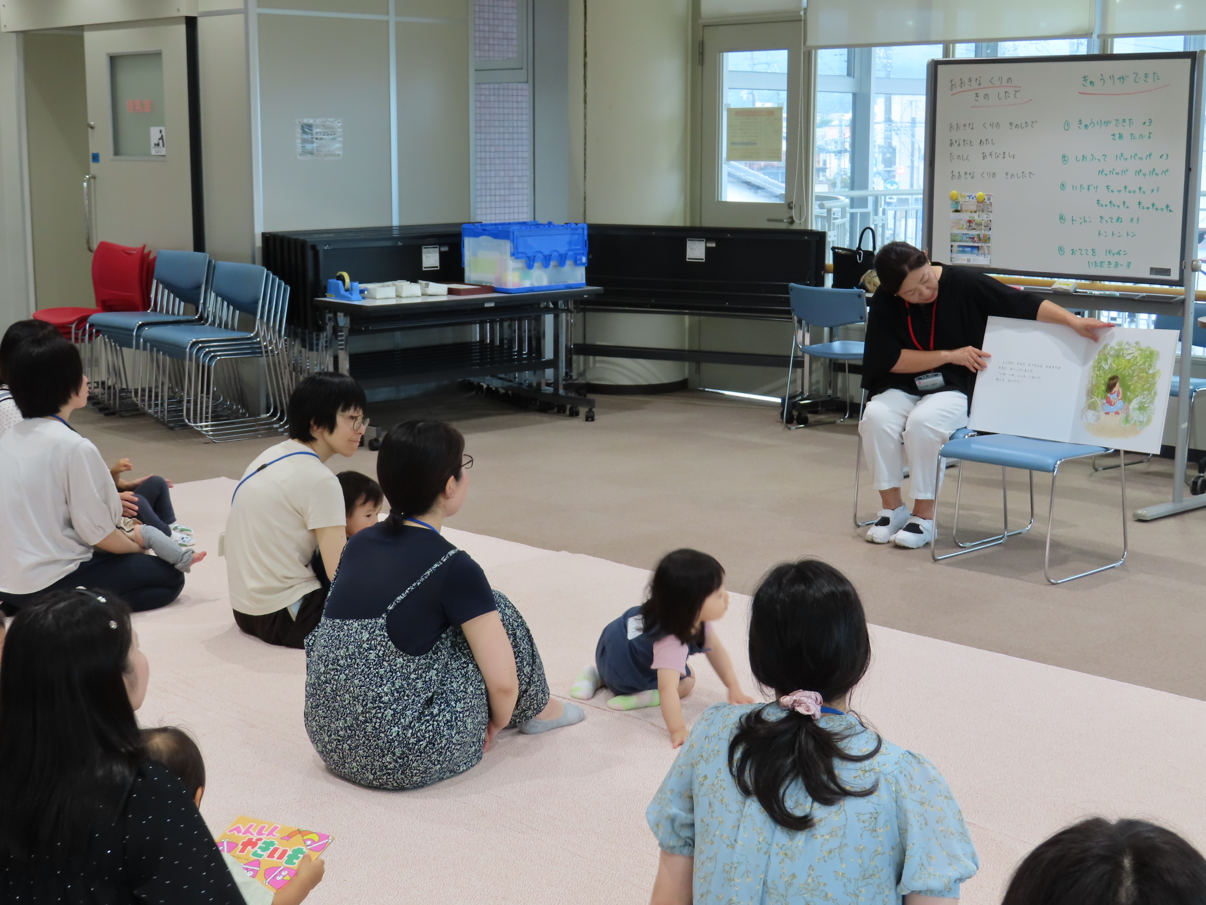 大型絵本「はっぱのおうち」の読み聞かせを聞いている様子