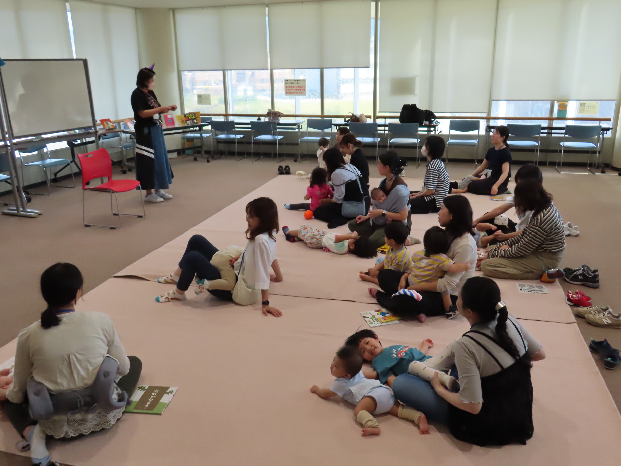 絨毯の上で寝ころんで親子のふれあい遊び「ラララぞうきん」をしている様子。