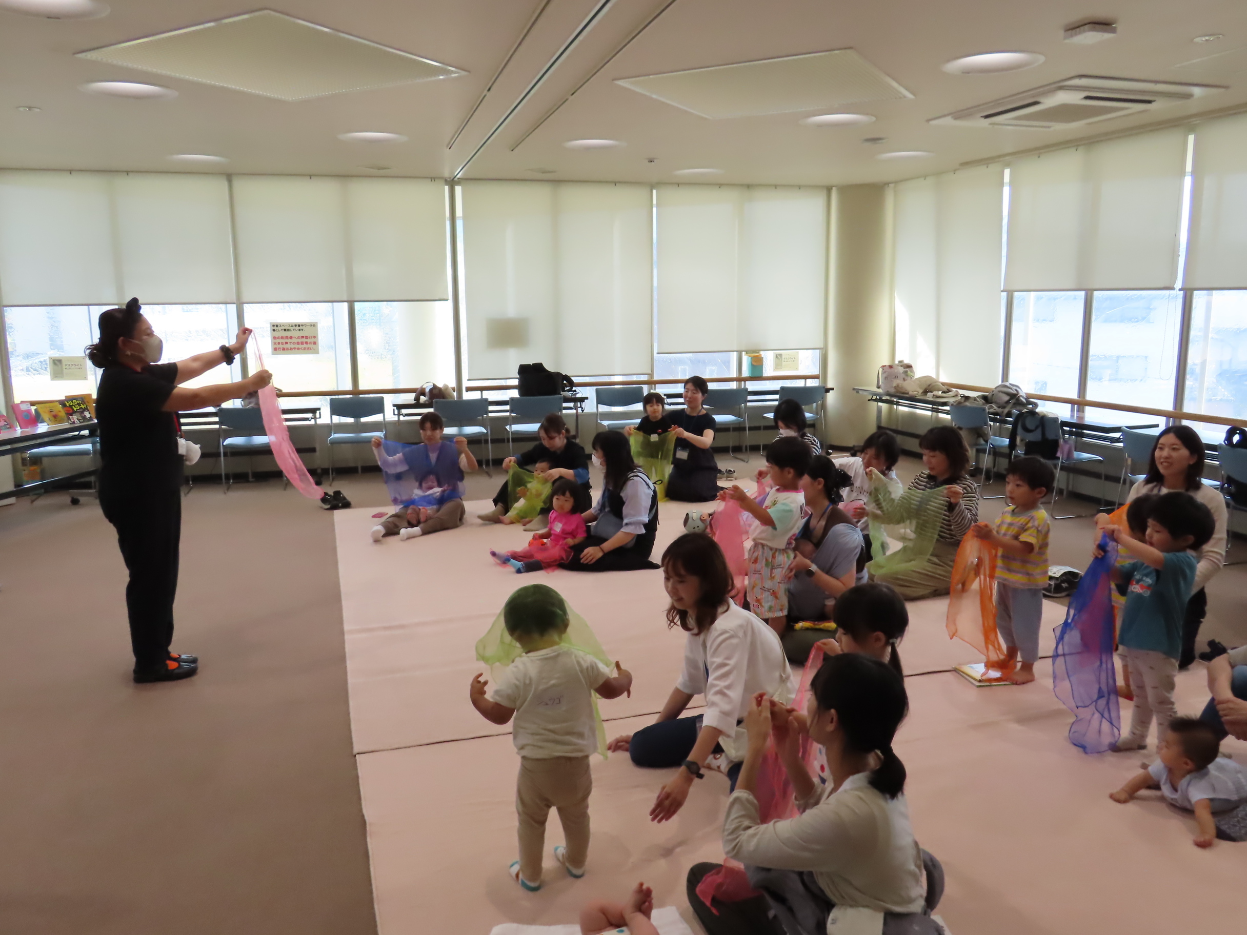 色とりどりのスカーフを使って、曲に合わせて体を動かして幼児が遊んでいる様子