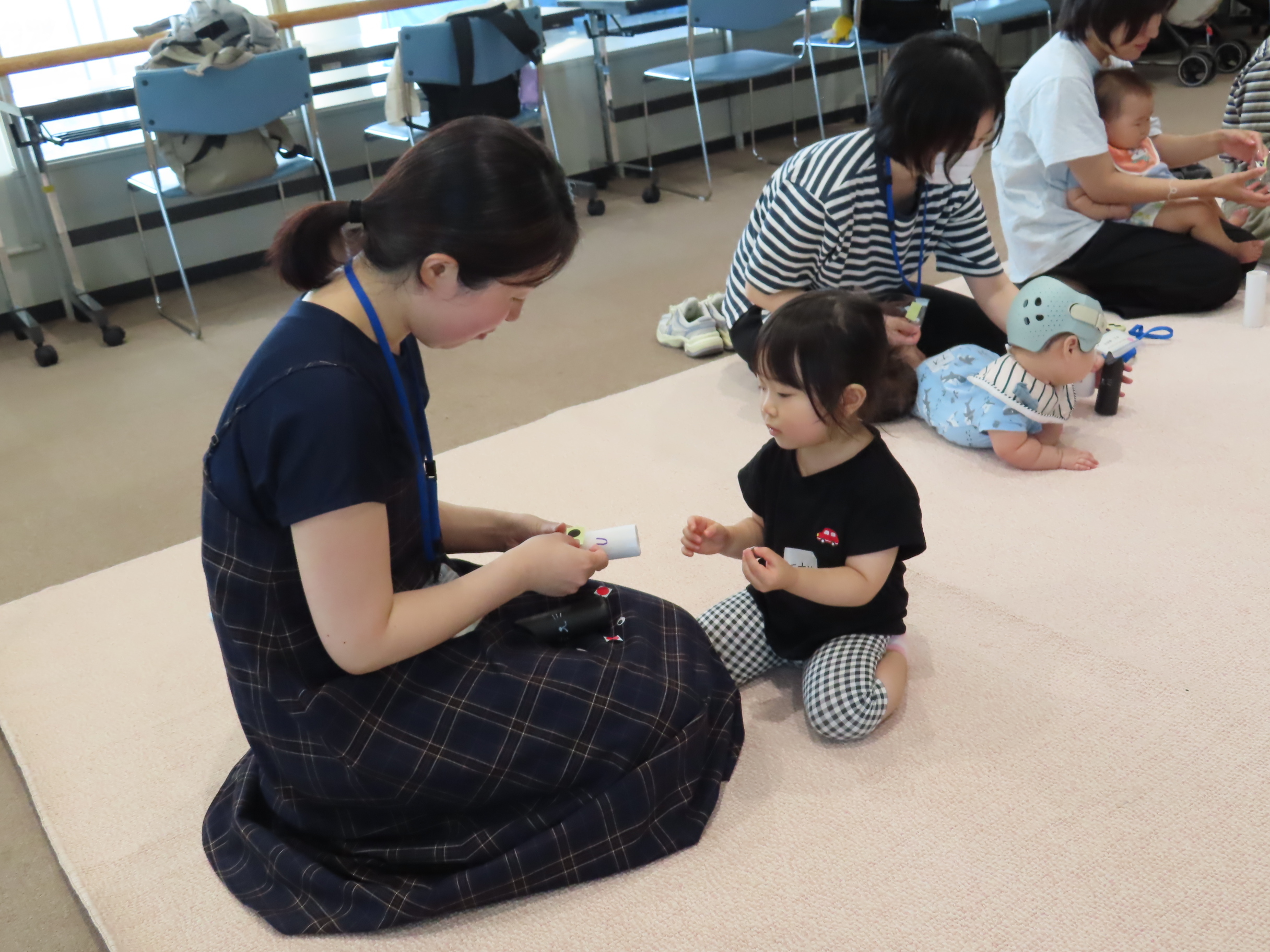 シールを貼って工作をしている親子の写真