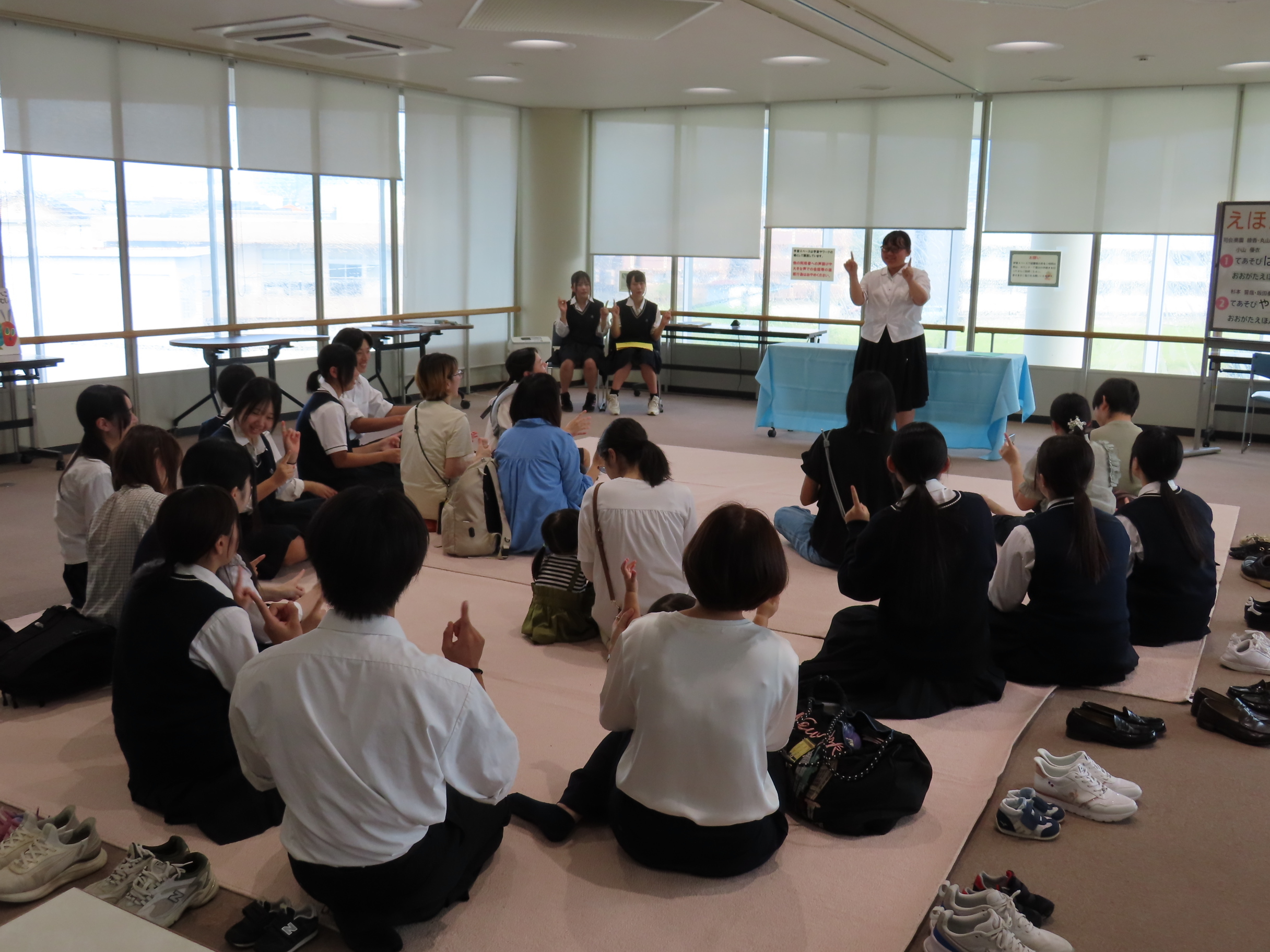 展示室で生徒が手遊びを子どもたちに披露している様子