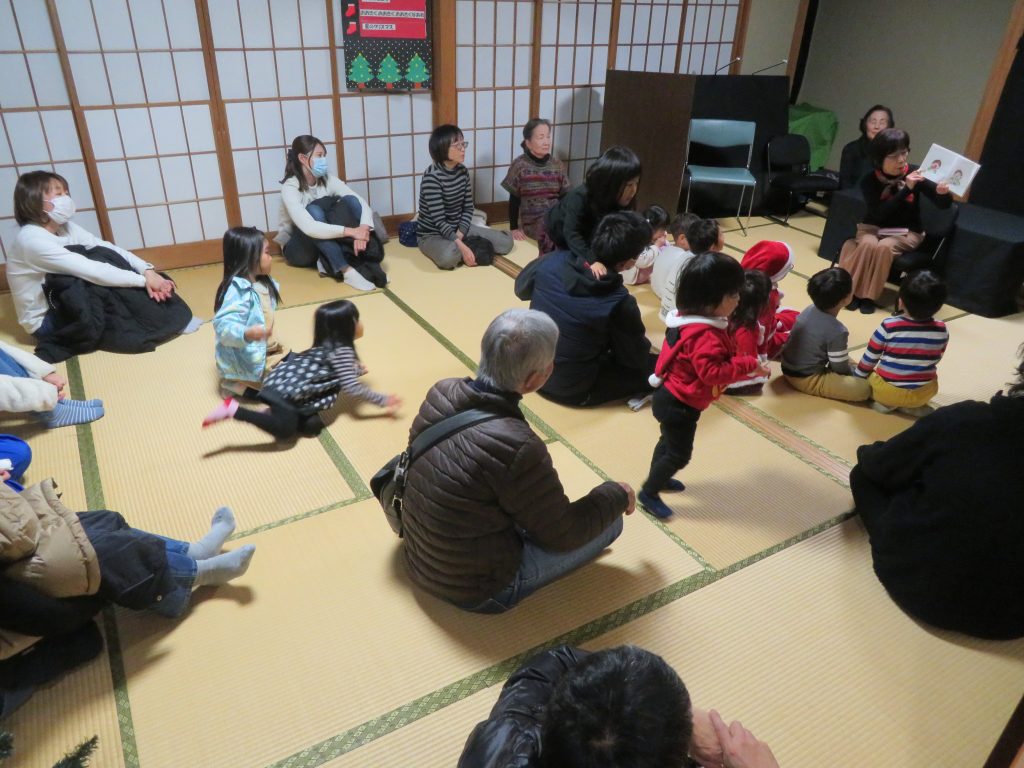 子供たちと大人が座っている和室での集まりの様子