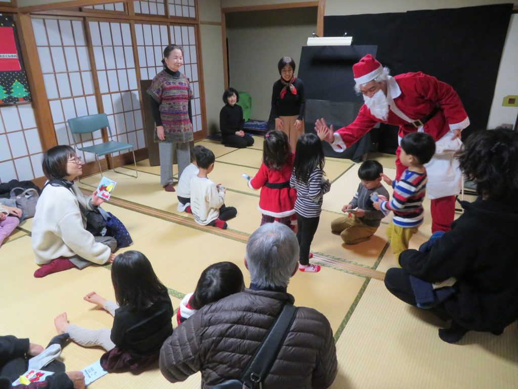サンタクロースが子供たちと交流しているクリスマスのイベントの様子。