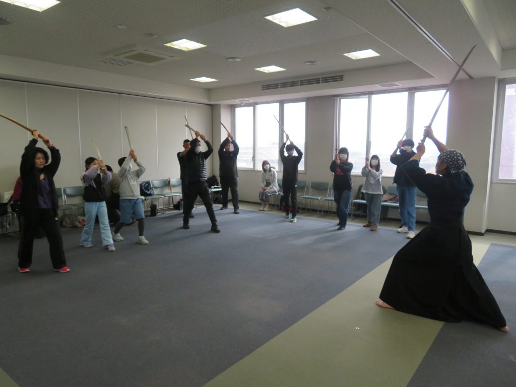 武道の稽古を行っている人々が集まっている室内の風景