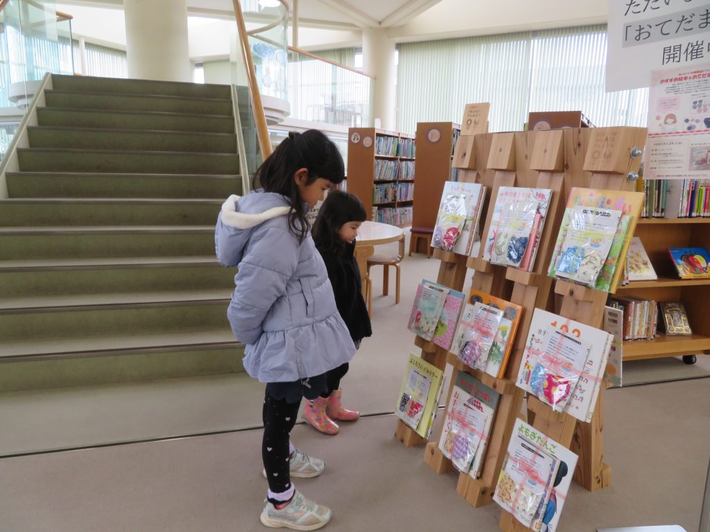 図書館で本を見ている二人の子供の写真
