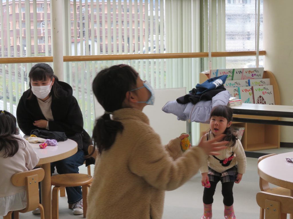 子供たちが室内で遊んでいる様子で、一人の子供が楽しそうに活動している。