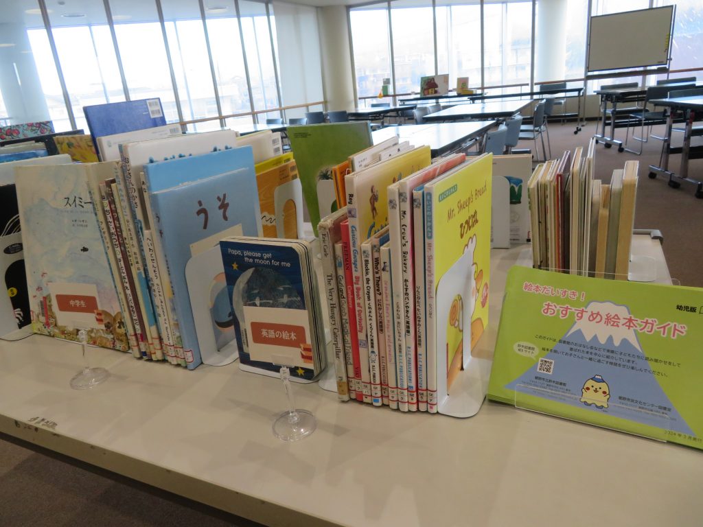 テーブルの上に並べられた多様な本がある図書館の内部の様子