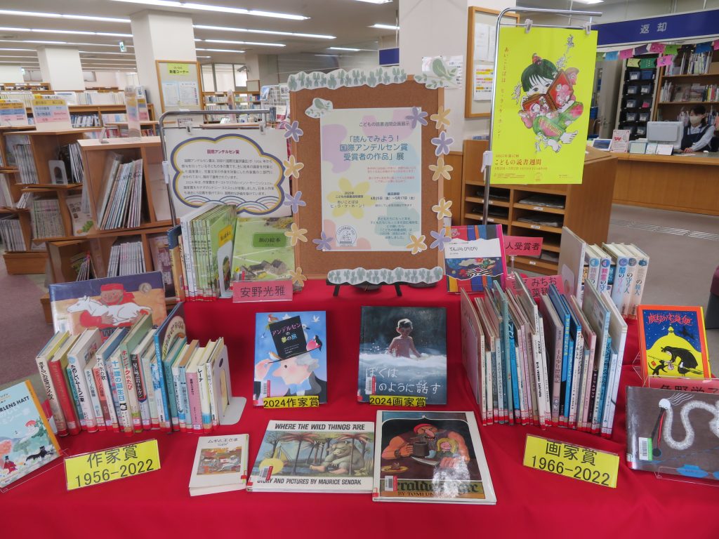 図書館のテーブルに並べられた本やポスターが置かれている様子。