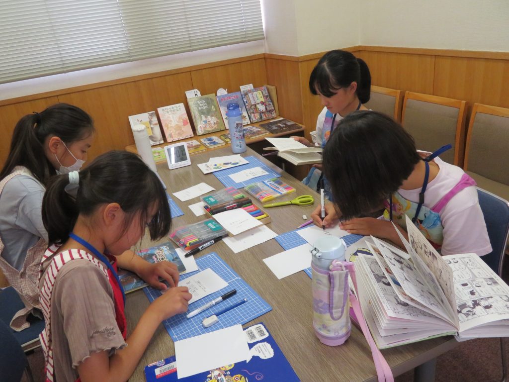 子供たちがテーブルで作品を制作している様子