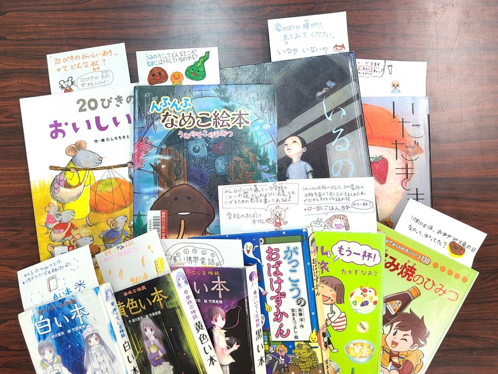 様々な絵本が重なって並んでいる画像。