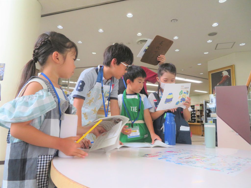 子供たちが図書館で本を見ながら話し合っている様子。