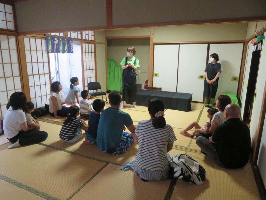 和室で話を聞く人々が座っている様子