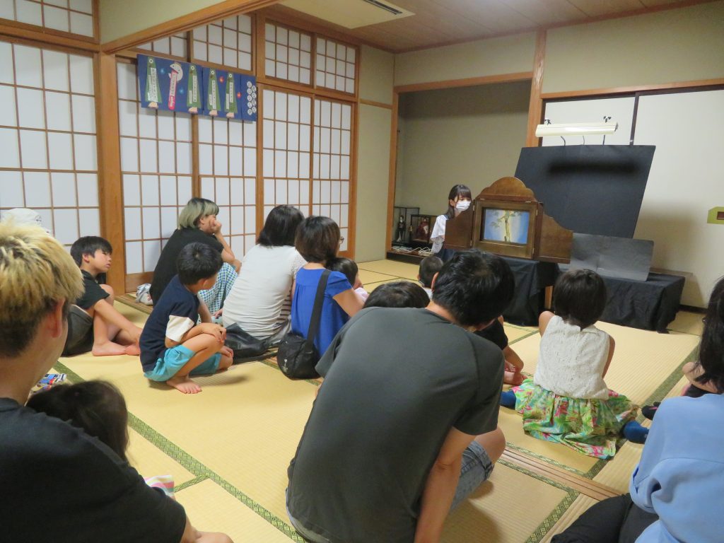 子供たちが和室で何かを見ている様子の画像