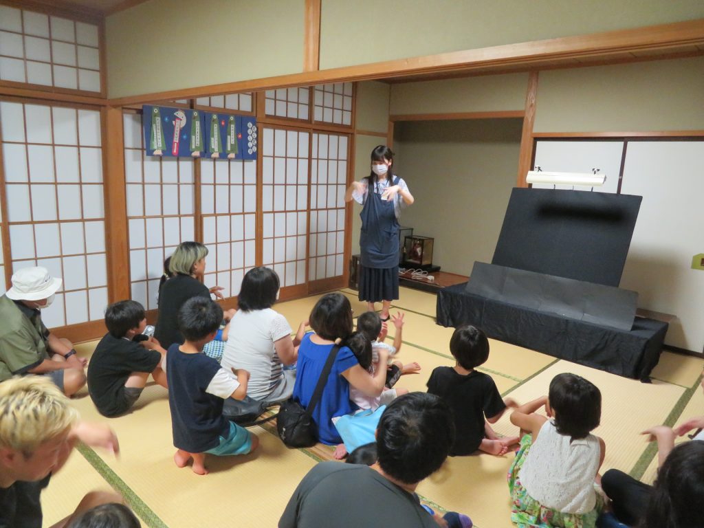 子供たちが座っている部屋で、講師が話している様子。