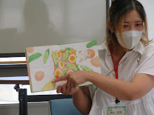 本を持っている人が教室で何かを説明している様子。