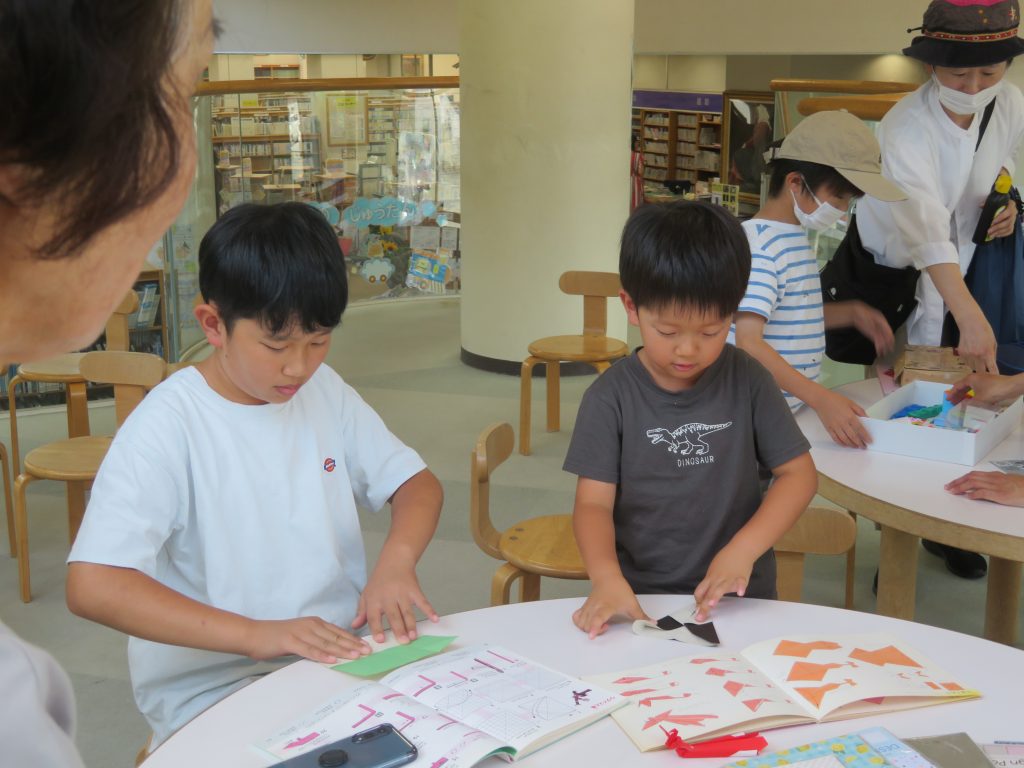 子供たちがテーブルで工作をしている様子の画像