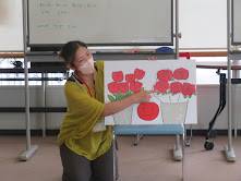 子供がカラフルな絵を持っている様子。