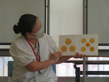 女性が絵本を指さしている様子。