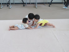 2人の子どもが地面に寝転んで遊んでいる様子。