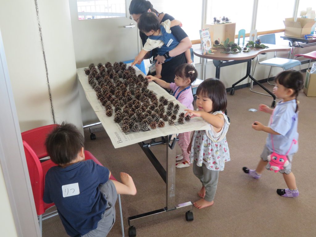 子供たちがテーブルの上で何かを扱っている様子が描かれた室内の画像。