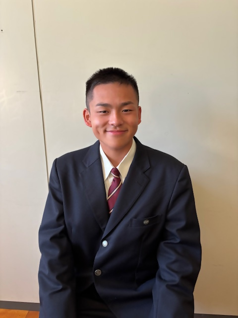 スーツを着た男性が座っている写真です。