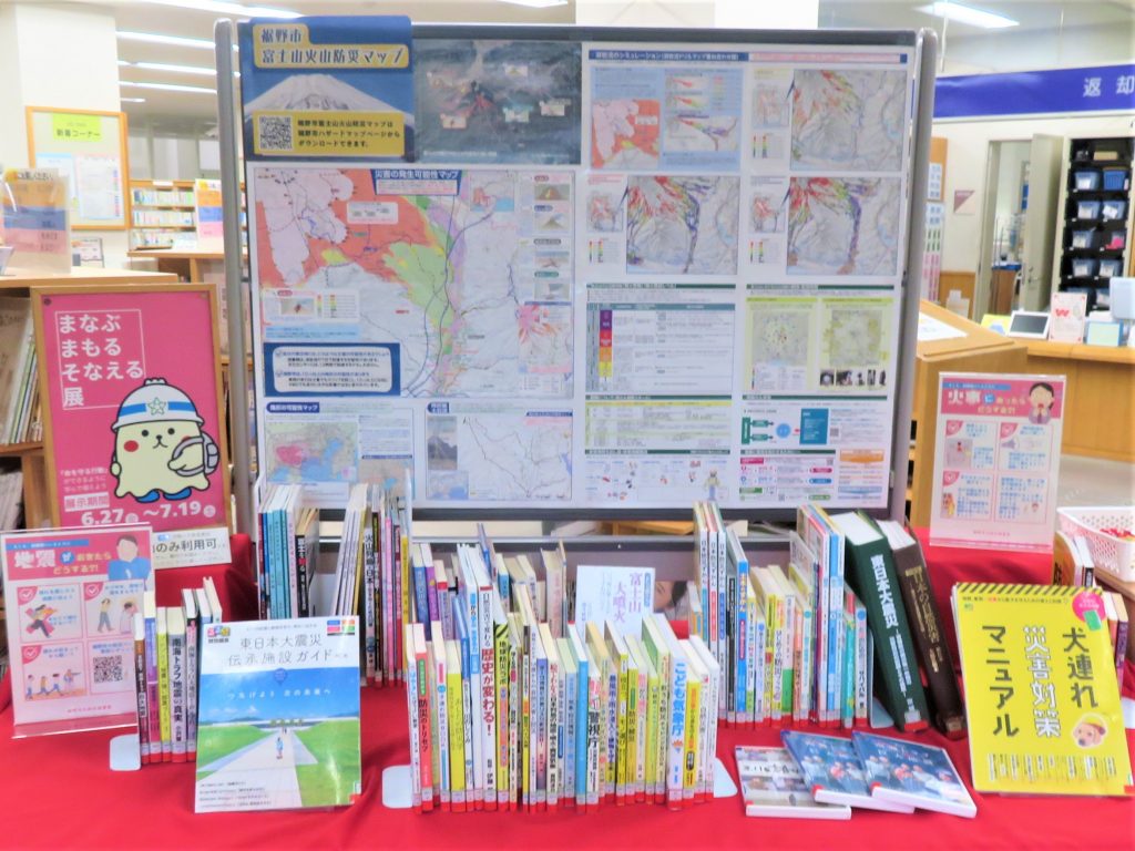 図書館の掲示板と本が並ぶテーブルの画像