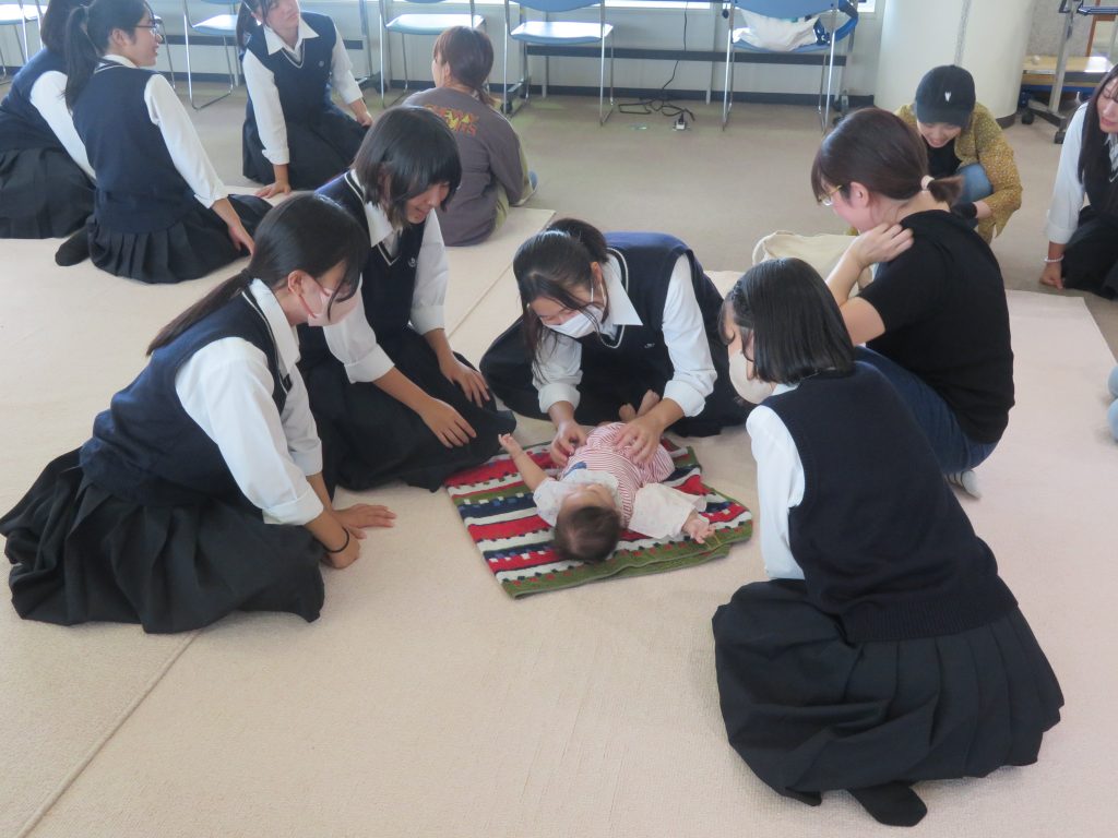 子供たちが床に座って遊んでいる様子で、おもちゃを使っている場面が描かれている。